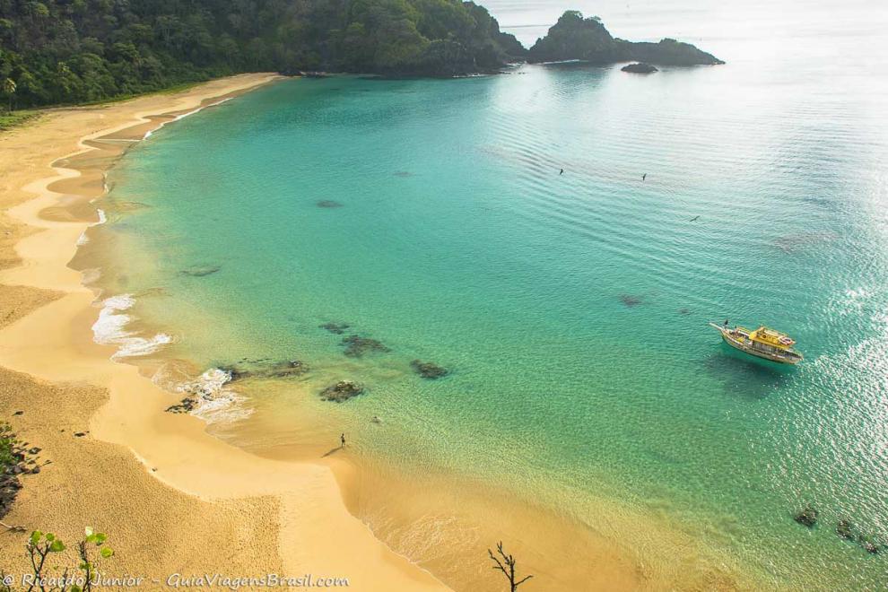 Imagem do alto da Praia do Sancho e suas águas transparentes.